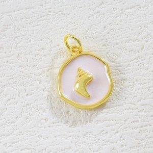 Macro detail of a 18K gold shell pendant with pink enamel for jewelry making