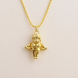 Macro detail of golden cupid angel pendant with bead chain on beige background