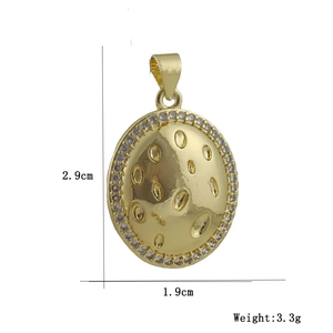 Macro view of gold plated oval pendant with zircon rim and hammered center texture
