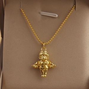 Macro shot of a golden Cupid angel pendant with detailed wings on a sleek metal ball chain