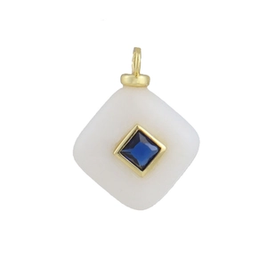Macro detail of a diamond-encrusted rhombic agate pendant with a blue zircon center stone