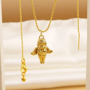 Macro shot of a golden cupid angel pendant with bead chain on white silk background