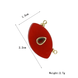 Detailed view of red eye-shaped charm with gold trim and exact dimensions 2.2x1.5cm
