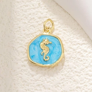 Macro view of gold plated seahorse pendant with blue glitter enamel for DIY jewelry