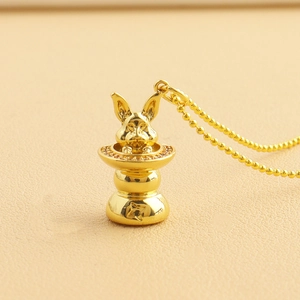 Macro shot of gold rabbit pendant in hat with sparkling crystals on a beaded chain