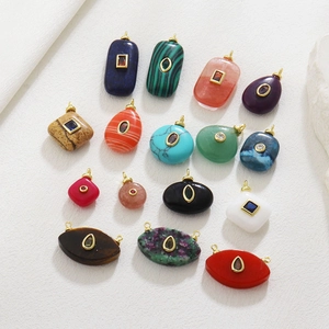 Macro detail of assorted natural stone pendants with gold-plated loops and inlaid crystals
