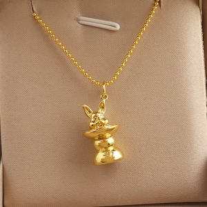 Detailed close-up of golden ball chain necklace with cute zodiac rabbit pendant