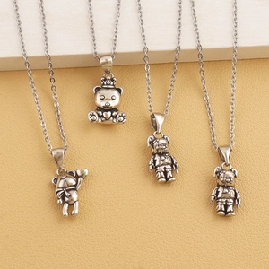 Detailed view of four vintage silver bear pendant necklaces with various designs and textures