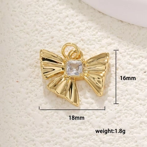 Macro shot of 16mm gold butterfly pendant with square zircon and precise dimensions