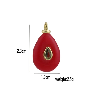 Vista macro del ciondolo a goccia rosso con bordi dorati, altezza 2,3 cm e peso 2,5 g