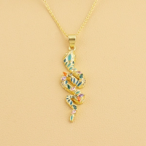 Macro shot of gold snake pendant necklace featuring green enamel and colorful zircons