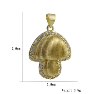 Vista dettagliata di un ciondolo a fungo dorato con zirconi bianchi, 2,9cm per 1,9cm