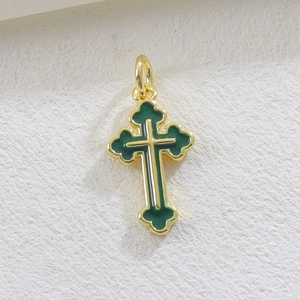 Dettaglio del ciondolo a croce dorata 18k con smalto verde scuro e finitura a strati
