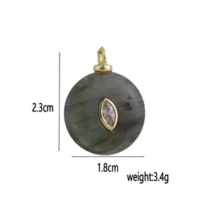 Dettaglio di un ciondolo tondo in labradorite con zircone e dimensione di 2,3 cm di altezza