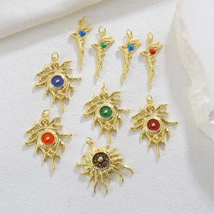 Detail of golden Evil Eye pendants with bird and sunburst designs on white marble