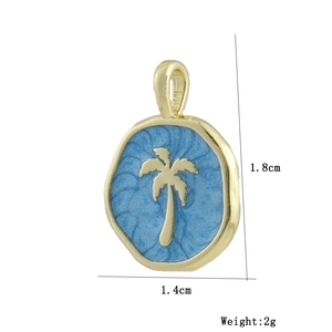 Detalle de colgante de palmera bañado en oro 18k con esmalte azul, 1,8cm x 1,4cm