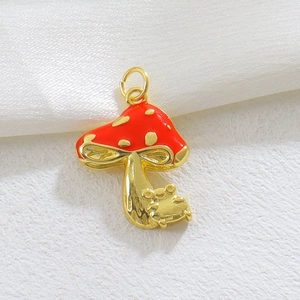 Detalle de un colgante de hongo rojo y dorado en esmalte brillante con acabado 18k