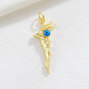 Detailed view of a gold-plated Evil Eye feather pendant on a soft textured background
