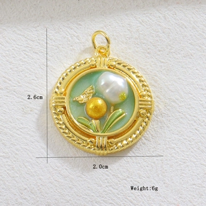 Vista detallada del colgante de corazón esmaltado verde con insecto dorado y perlas