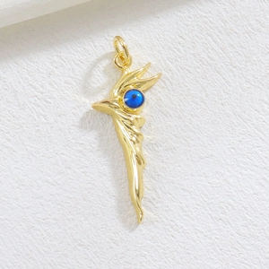 Close-up of golden flame evil eye pendant with blue bead detail and metallic sheen