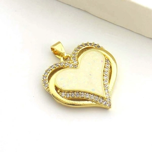 Vista macro de un colgante de corazón de oro 18k con opalo blanco y circonitas