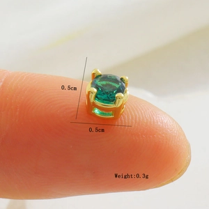Détail d'une puce d'oreille en pierre verte de 0,5cm avec serti à quatre griffes dorées