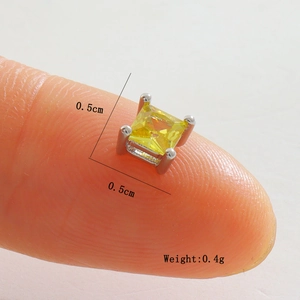 Macro détaillée d'une boucle d'oreille carrée en zircon de 0,5 cm sur monture argent