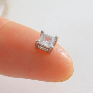 Vue macro d'une petite perle de cristal carrée sur un serti argenté à quatre griffes