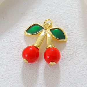 Makroaufnahme der roten Kirsche mit goldenem Stiel und grünen Blättern für DIY-Schmuck