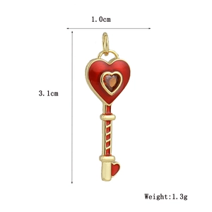 Detalle de un colgante de llave bañada en oro 18k con esmalte de corazón y circón