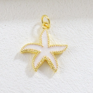 Detail of a golden starfish charm with pink enamel and subtle glitter for DIY jewelry