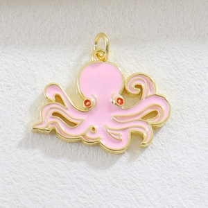 Macro shot of octopus jewelry pendant with pink enamel coating and gold-plated finish