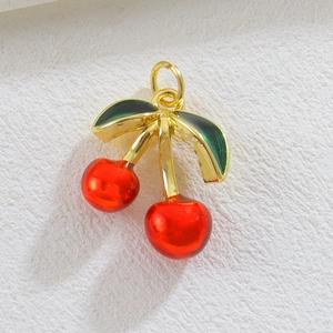 Handgefertigter Kirsch-Anhänger mit roter Harzfrucht und Gold-Metallblatt im Makro