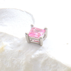 Détail macro d'un cristal rose carré taille princesse sur une monture argentée