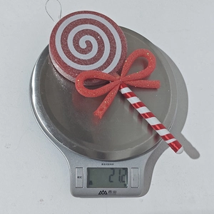 Detailed view of red and white Christmas lollipop ornament weighing 21.2g on a digital scale