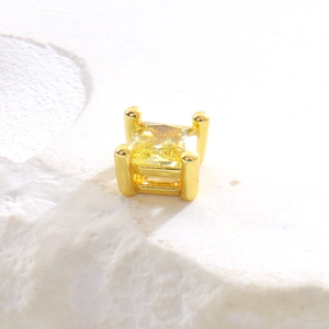 Détail de puce d'oreille en cristal jaune carré avec serti à quatre griffes plaqué or
