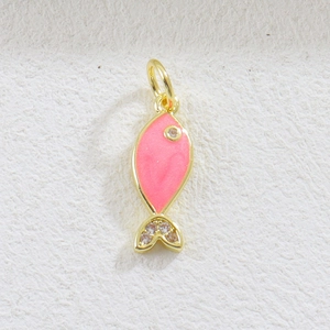 Macro detail of a gold fish pendant featuring pink enamel and sparkling crystals