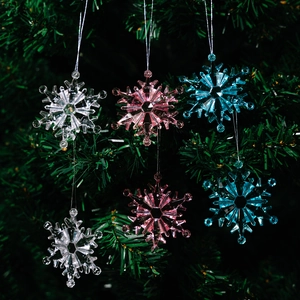 Set of 6 acrylic Christmas snowflake ornaments in pink, blue and clear on green tree