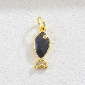 Detailed macro view of a golden fish charm with black enamel and sparkling zircon stones