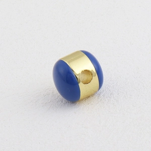 Detalle macro de la cuenta de esmalte azul y oro con agujero central para joyería DIY