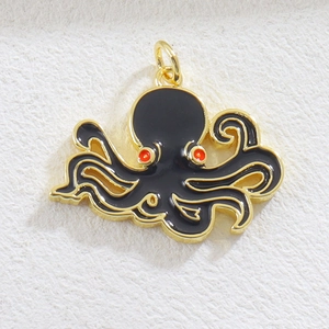 Detailed view of octopus charm with black enamel and red accents on gold-plated metal