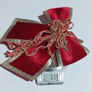 Macro view of large red velvet Christmas bow with gold sequin edges and metallic wire