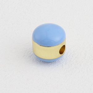 Detalle macro de cuenta de esmalte azul cielo con banda central de metal dorado 18k