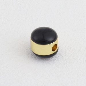 Detalle de una cuenta negra pulida con anillo de oro de 18k para creación de joyería