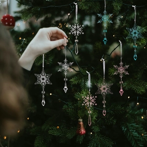 Sparkling crystal snowflake ornaments in pink and blue hanging on a Christmas tree