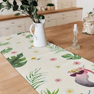 Tropical flamingo table runner with palm leaves on a wooden dining table