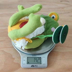 Detailaufnahme zeigt das tatsächliche Gewicht der grünen Frosch-Gnom-Puppe bei 142,9g