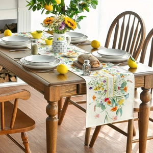 Linen table runner with spring wildflowers pattern on a rustic wooden dining table