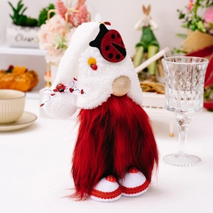 Détail d'un gnome coccinelle avec barbe rouge en peluche et bonnet blanc tricoté