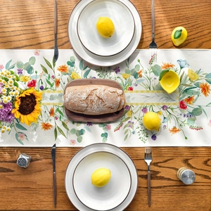 Spring wildflower table runner with sunflowers and daisies on a rustic wooden dining table